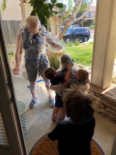 Daria and her husband greet her grandchildren wearing a bubble suit