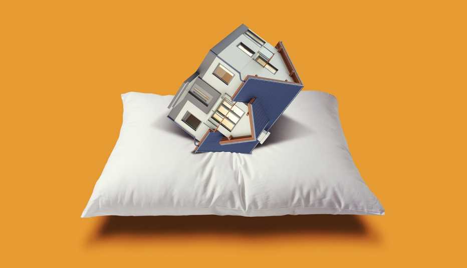 a house upside down on a white pillow over a yellow field