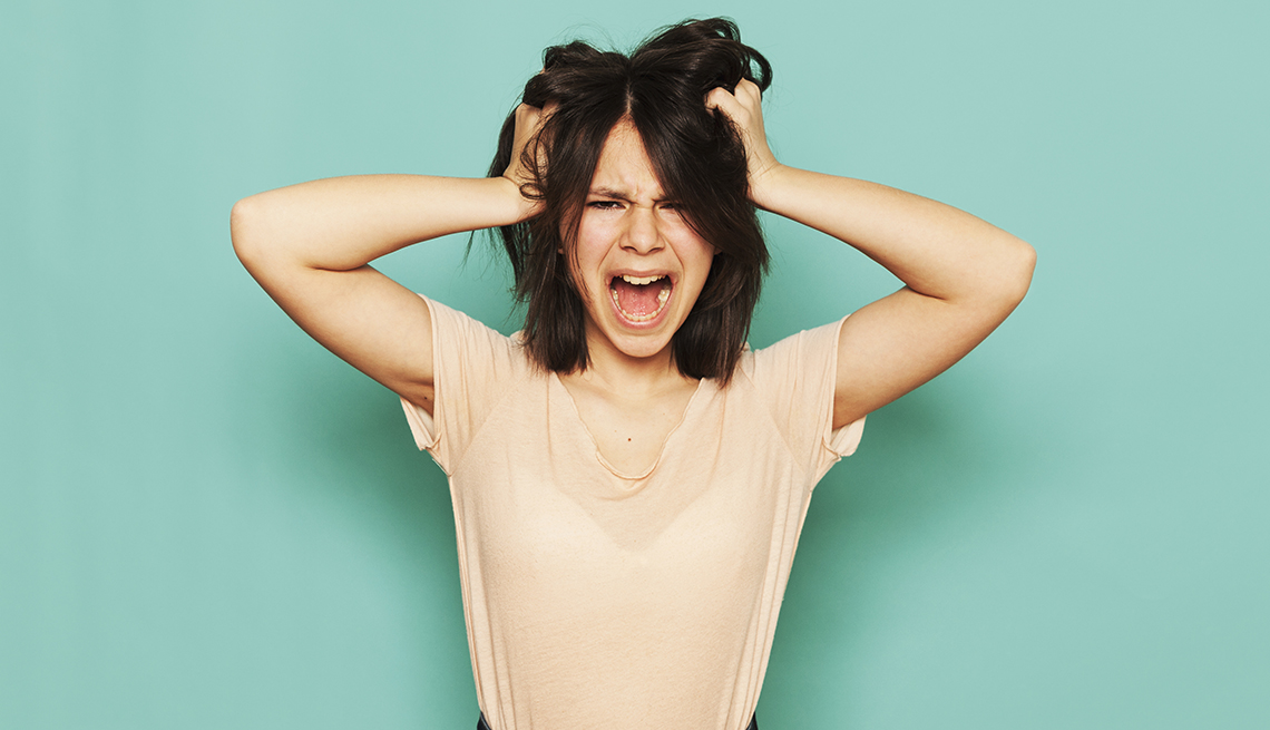 woman holding her head and yelling