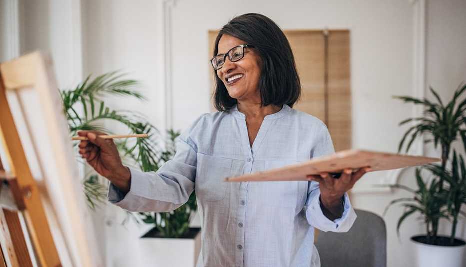woman smiling while painting in a living room