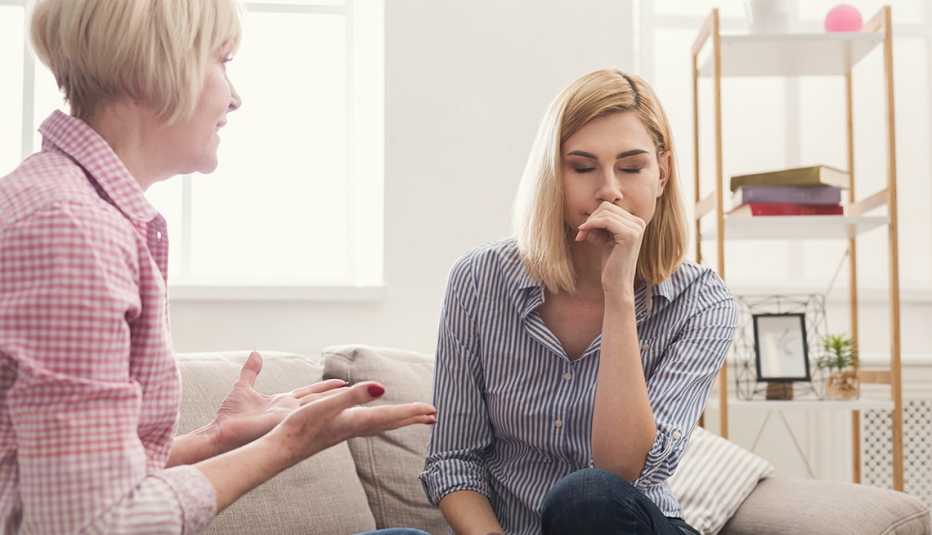 Portrait of angry adult mother shouting and swearing daughter while young woman closed eyes. Generation and relationship concept