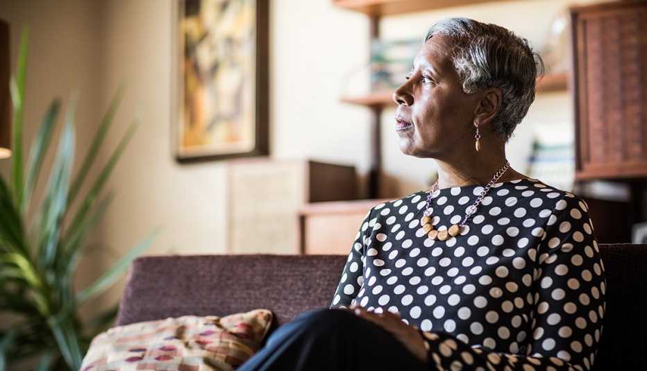 Woman sitting on a couch at home, looking lonely