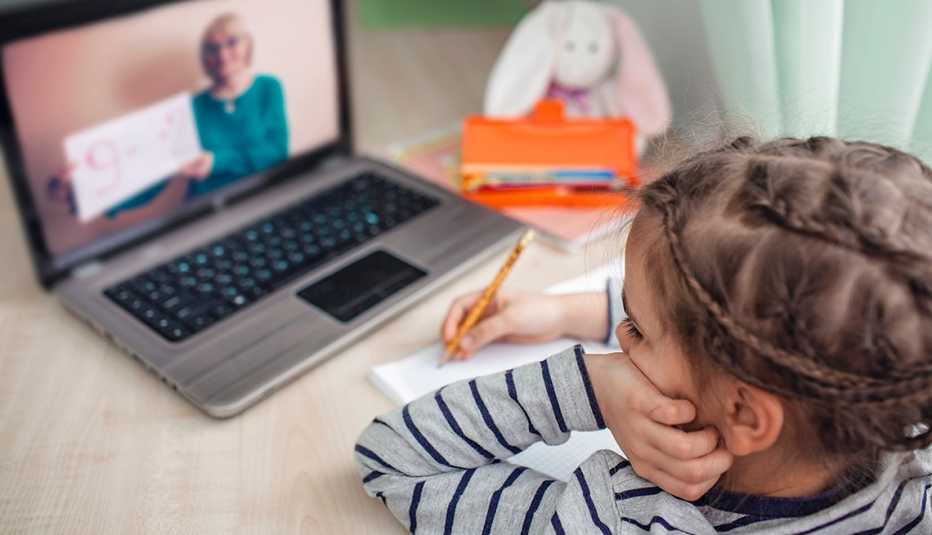 Schoolgirl studying homework math during her online lesson at home, social distance during quarantine, self-isolation, online education concept, home schooler