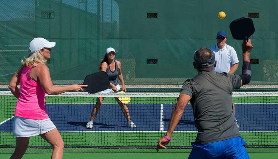 two couples playing a game of pickleball