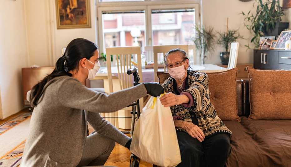 Woman gives groceries to another woman