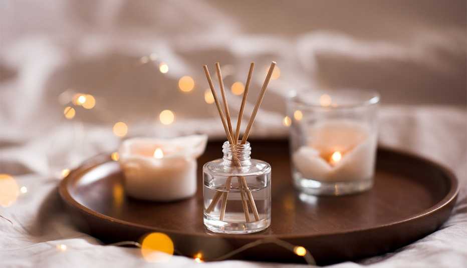 Home perfume in glass bottle with wood sticks and candles Home perfume in glass bottle with wood sticks and candles