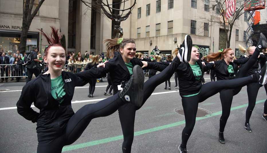 Dance team high steps in front of Rockefeller Center. 