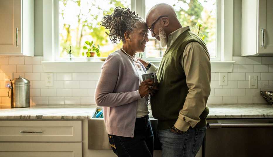 a loving couple stand in the kitchen