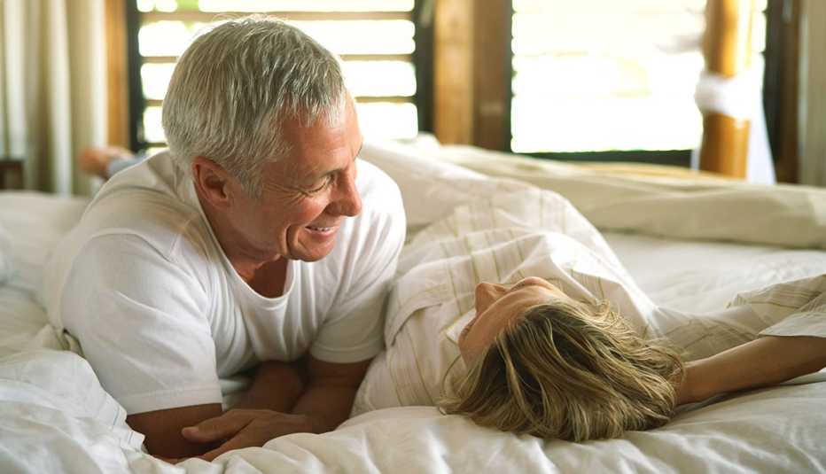 a couple laying on a bed talking with one another