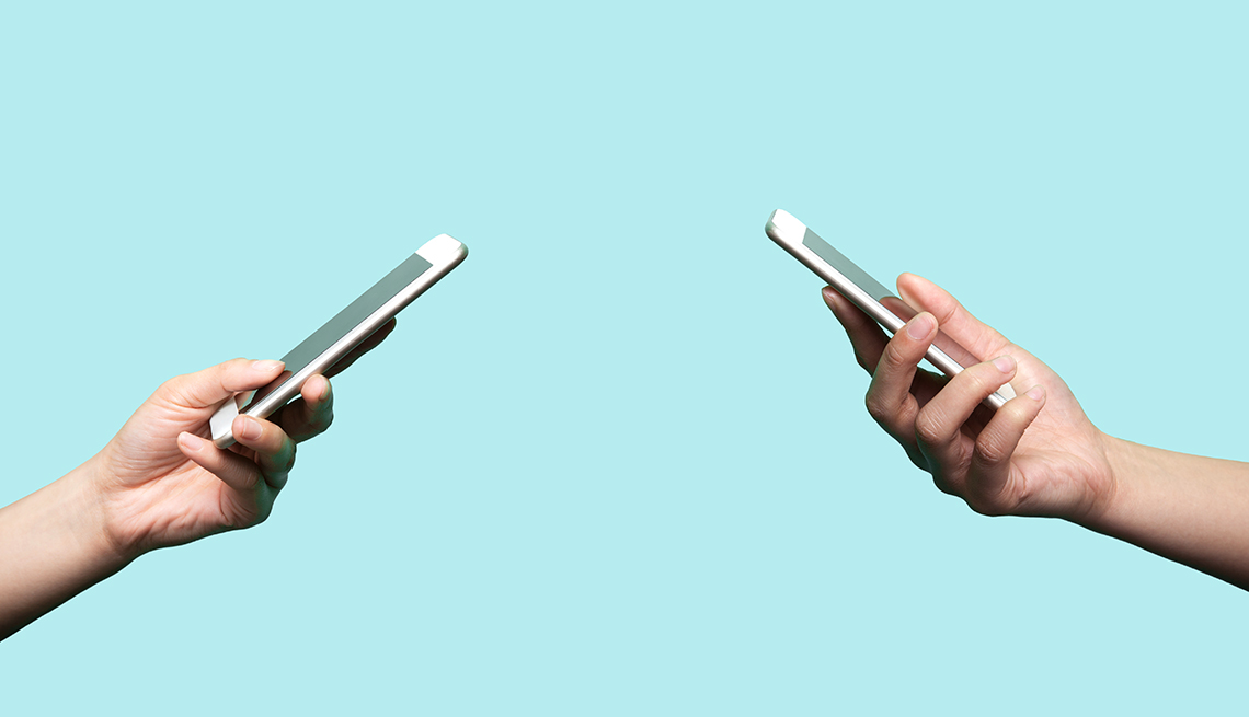 Two hands holding mobile phones
