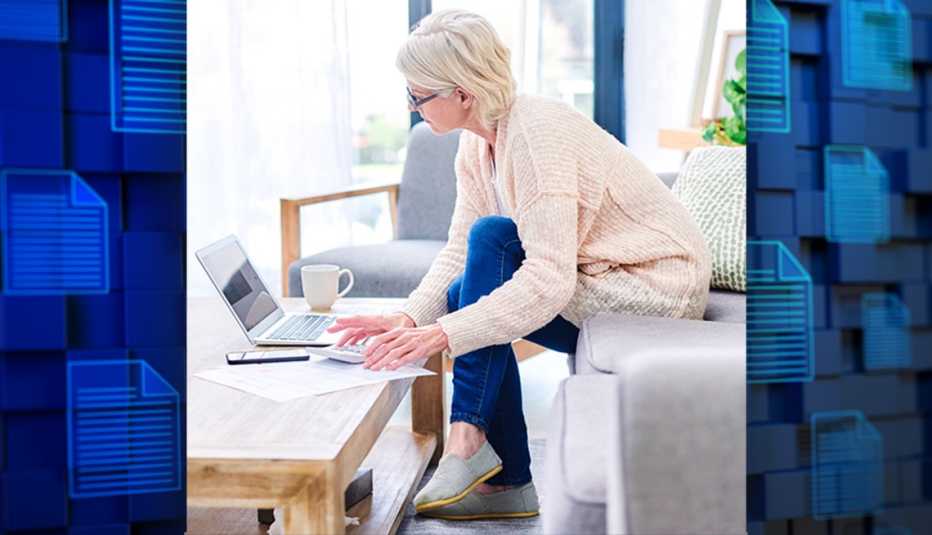 a woman doing digital asset planning on her laptop at home and the background shows digital files