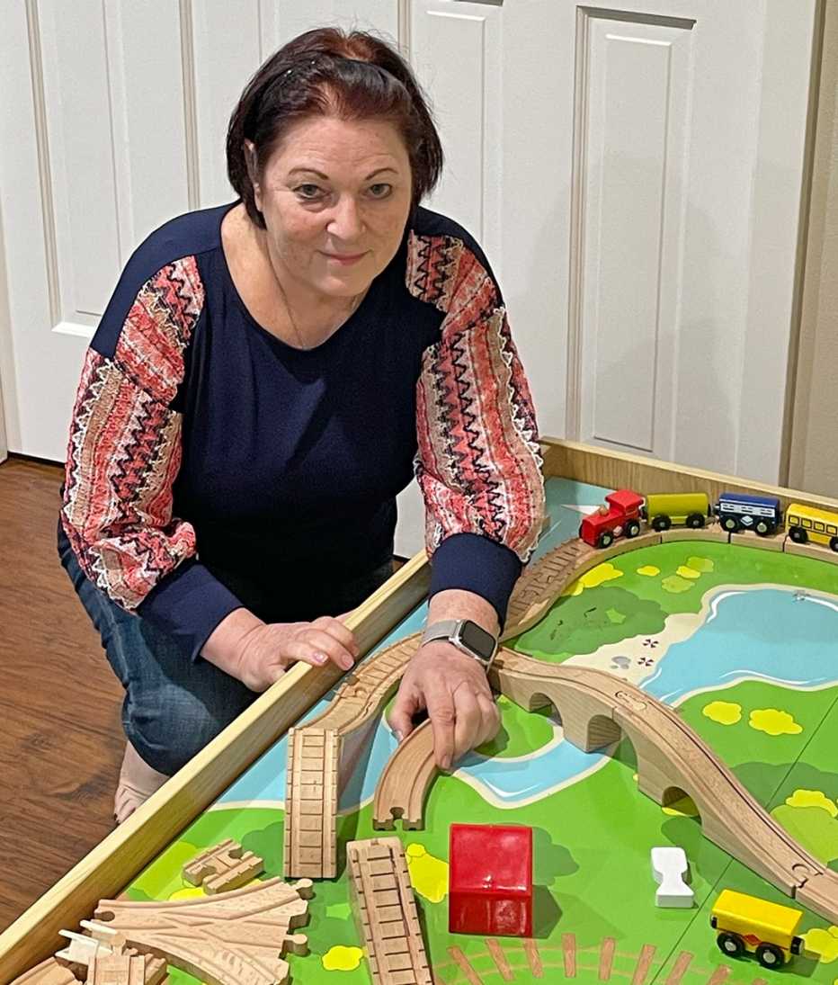elyse rosenburg sits next to her grandkids play table