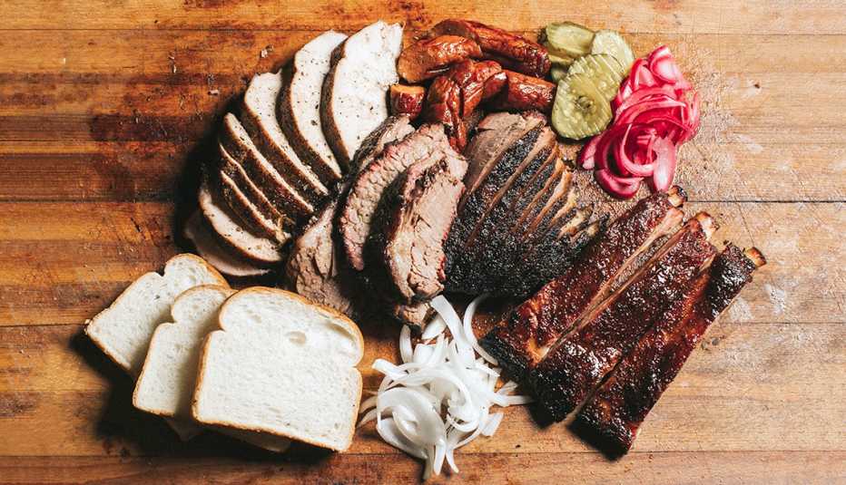a barbecue platter including meats and vegetables and bread