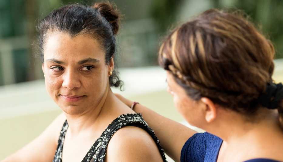 A female is comforted by a friend who offers kind words