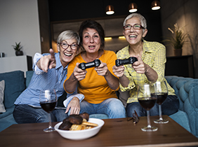 senior women having great time together playing video game
