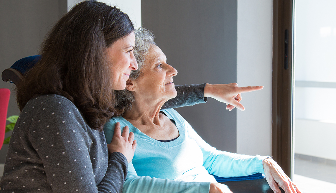 Two women sit together looking out a window
