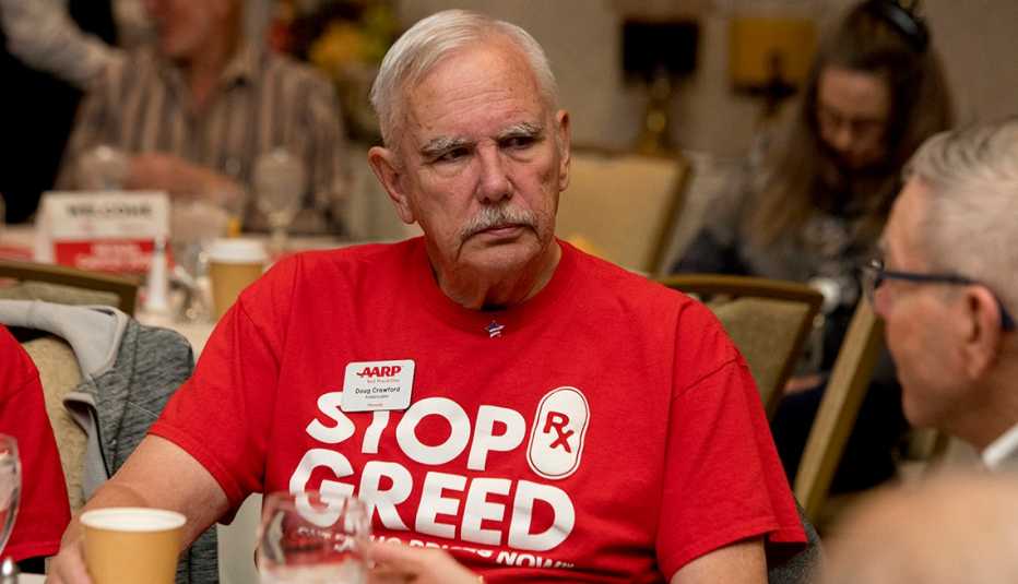 An older man wearing a red shirt at an event