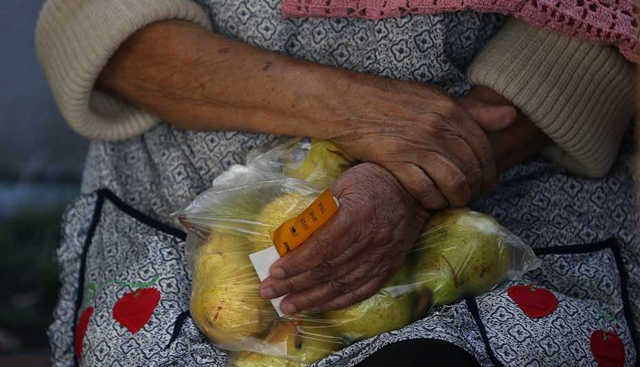 A woman is holding a bag of pears