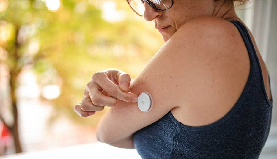 A diabetic patient checking her blood sugar by using  arm sensor device
