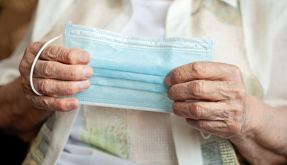 close up of a woman with dementia holding a face mask in her hands