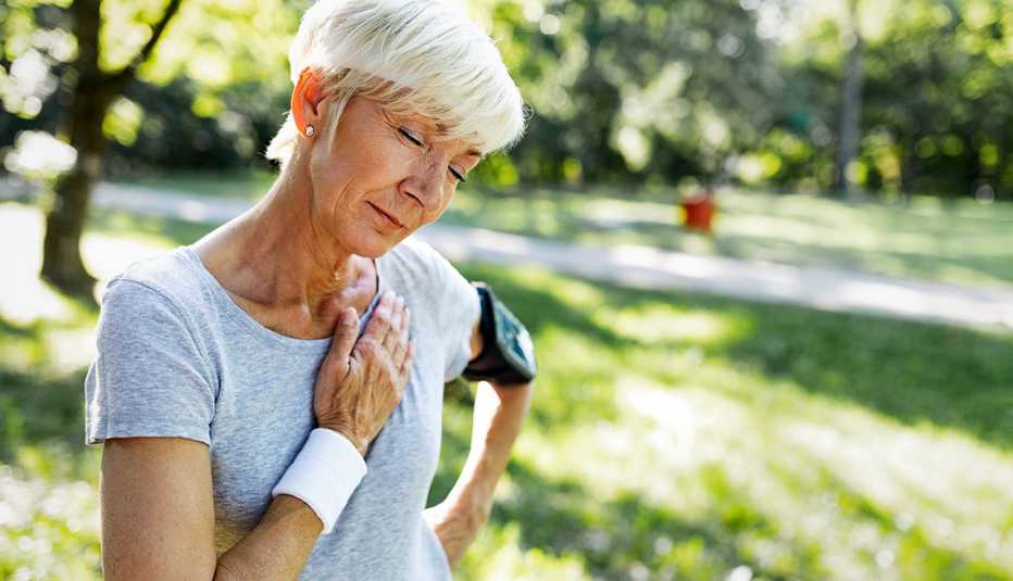 woman out on a jog touching her chest in discomfort