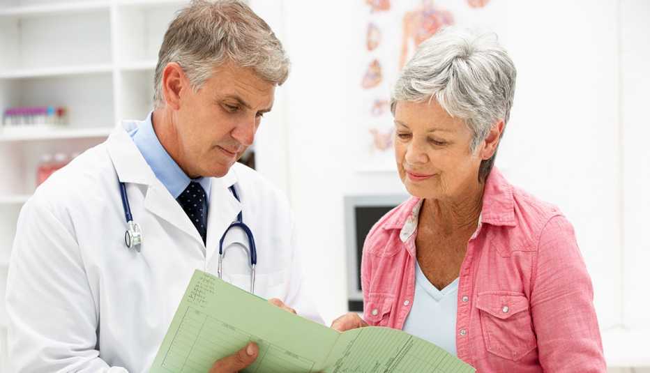 A doctor and a female patient are looking over medical documents