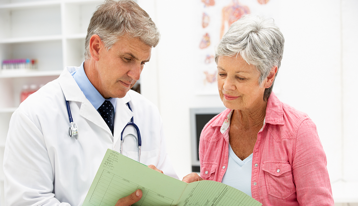 A doctor and a female patient are looking over medical documents