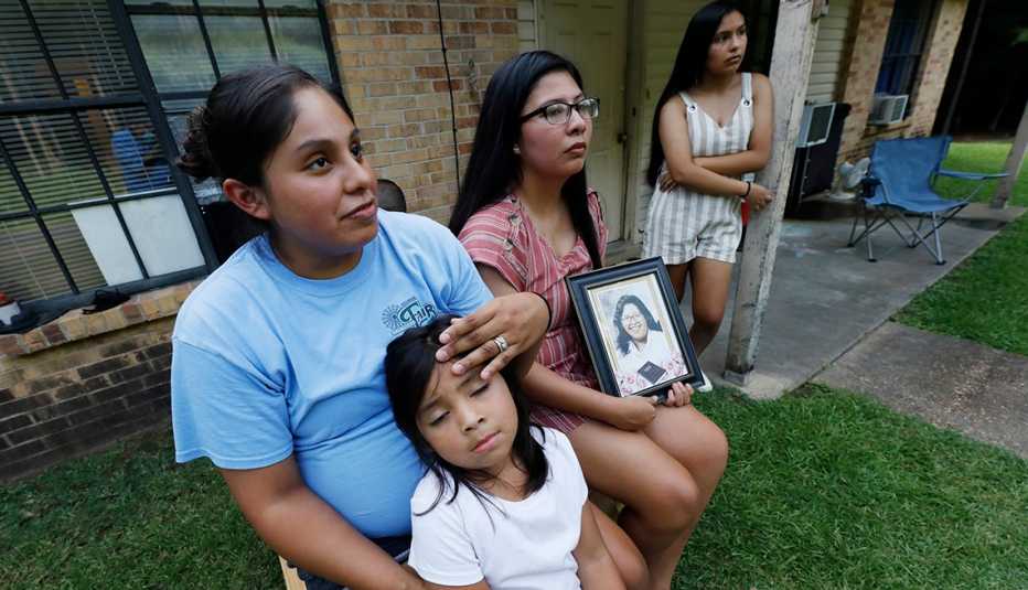Sisters Kristi Wishork, left, consoles her daughter Renaya Farmer, 5, as she and her sisters Kristina Taylor, center and Kaydee Taylor, right recall the family pride and love their late mother, Sharon Taylor, had for their family, Tuesday, July 21, 2020 o