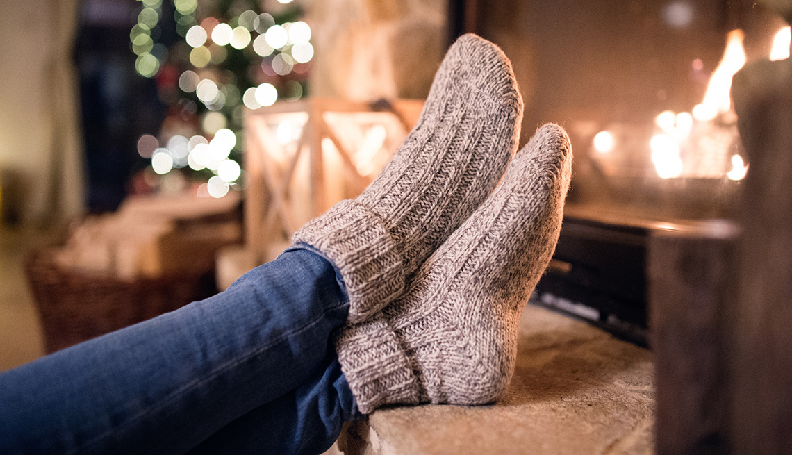 feet crossed with winter socks in front of a fire