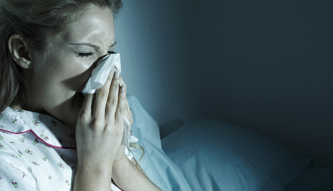 Woman with cold blowing her nose