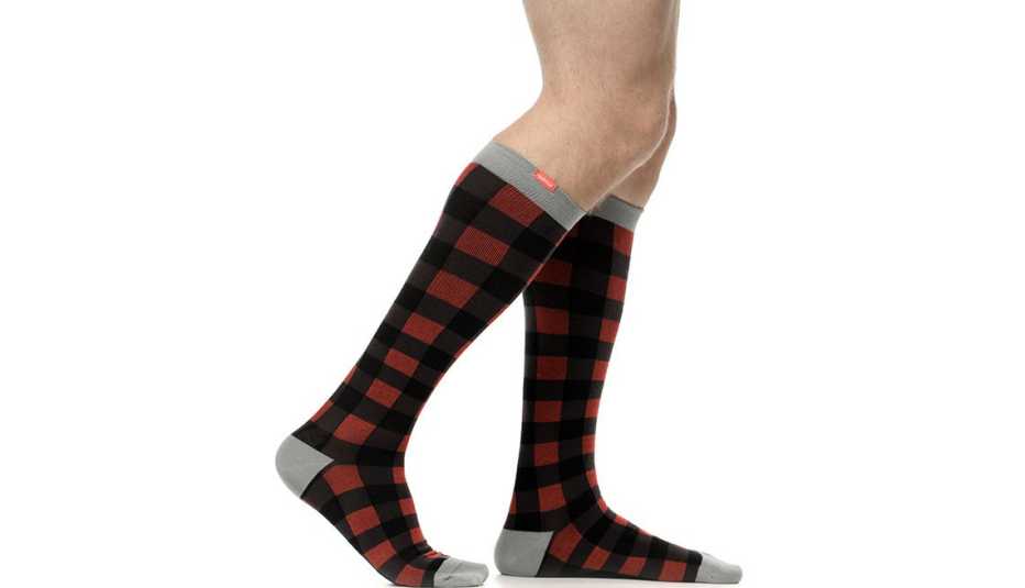 An image of a man wearing plaid knee high compression socks An image of a man wearing plaid knee high compression socks