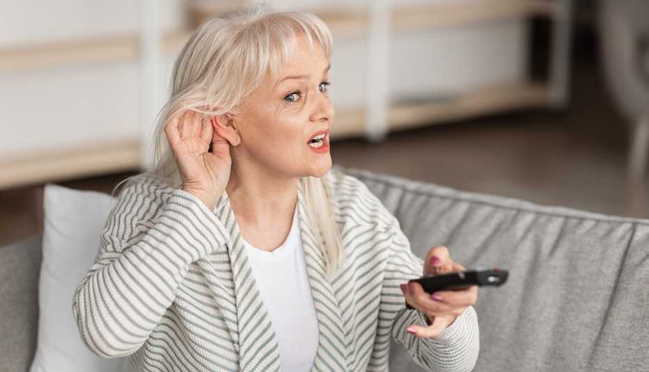 woman having trouble hearing the television woman having trouble hearing the television