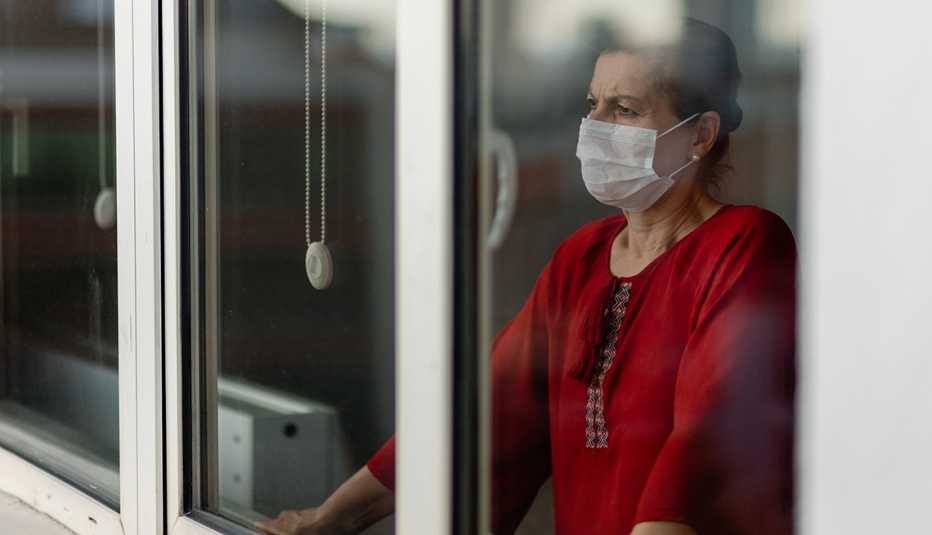 woman in mask at window woman in mask at window