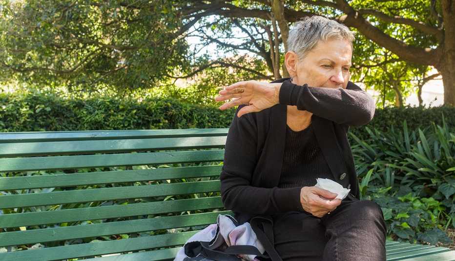 woman coughing into her elbow