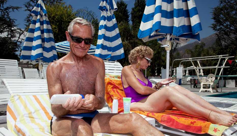 man and woman applying sunscreen