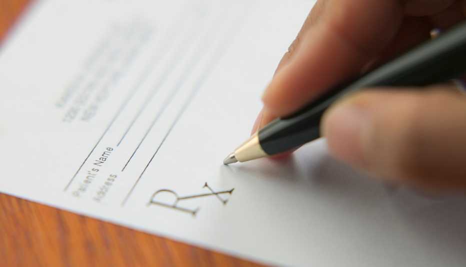Close up of a hand writing on a prescription pad.