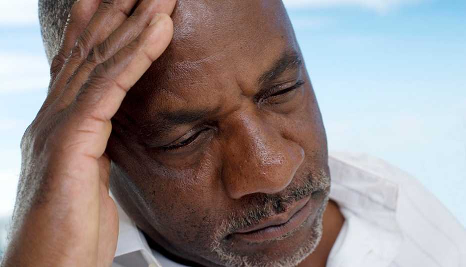 man with his head in his hand, looking depressed