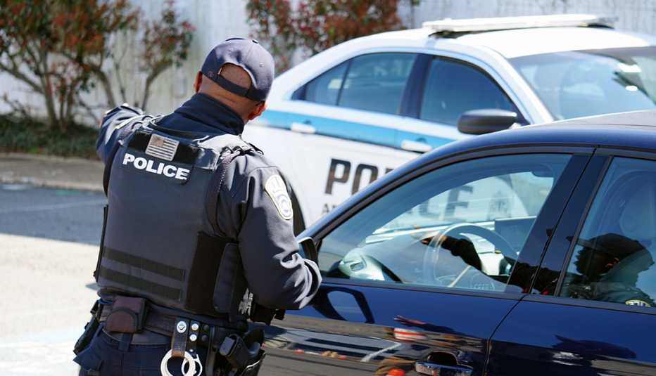 Police officer in Arlington County, Virginia guiding cars to COVID-19 drive-through testing center