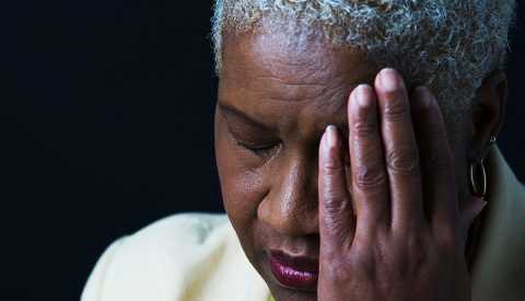 woman with headache holding head