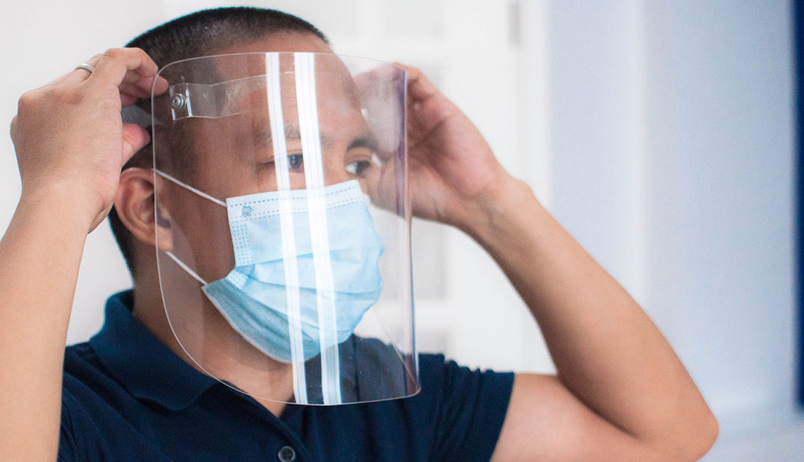 Photograph of a man wearing protective face mask and face shield in the office