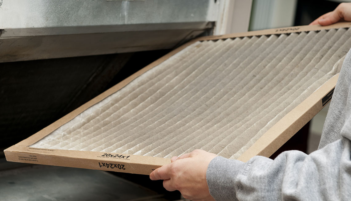 Home owner changing their dirty air filter.  