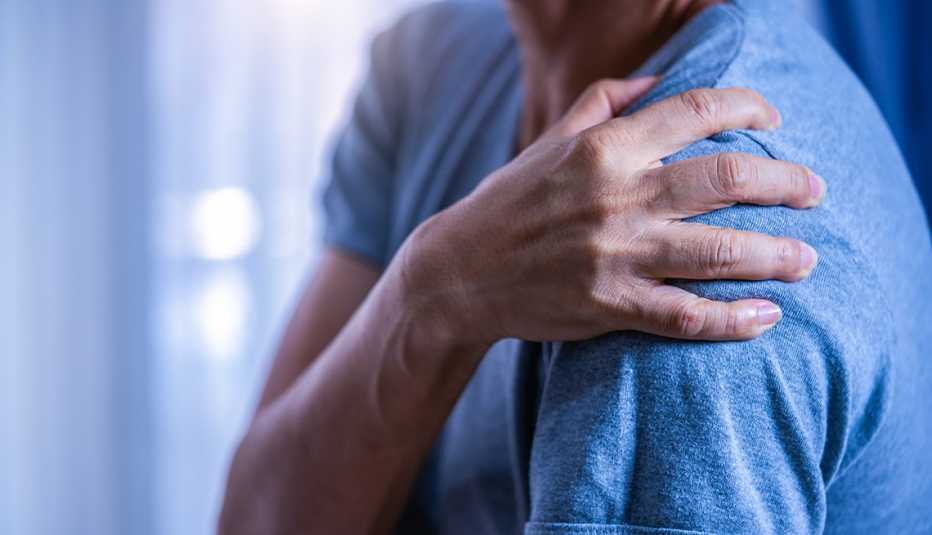man holds painful shoulder