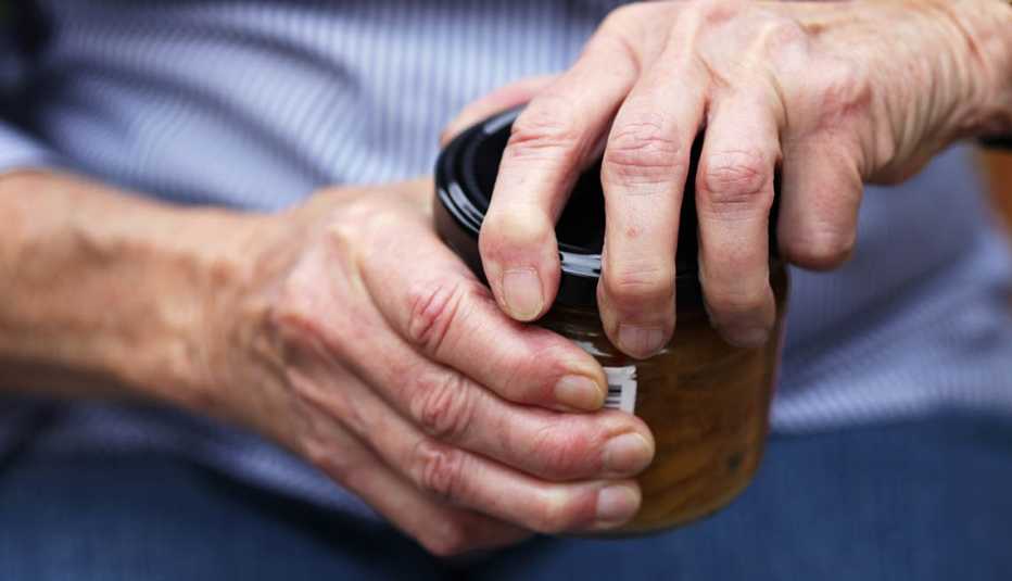 Person trying to open tough jar lid