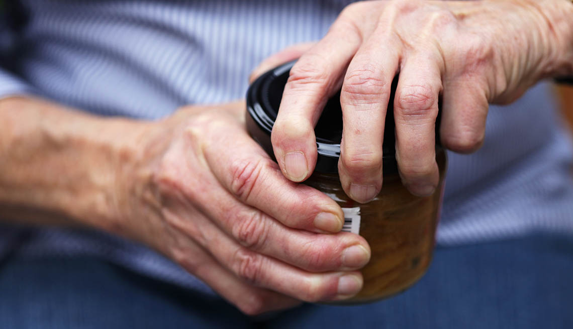 Person trying to open tough jar lid