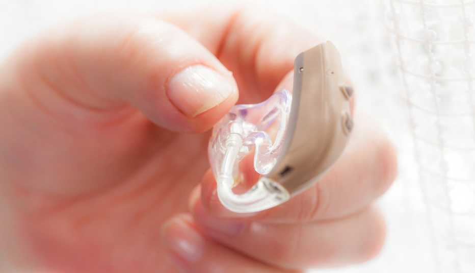 person holding a hearing aid