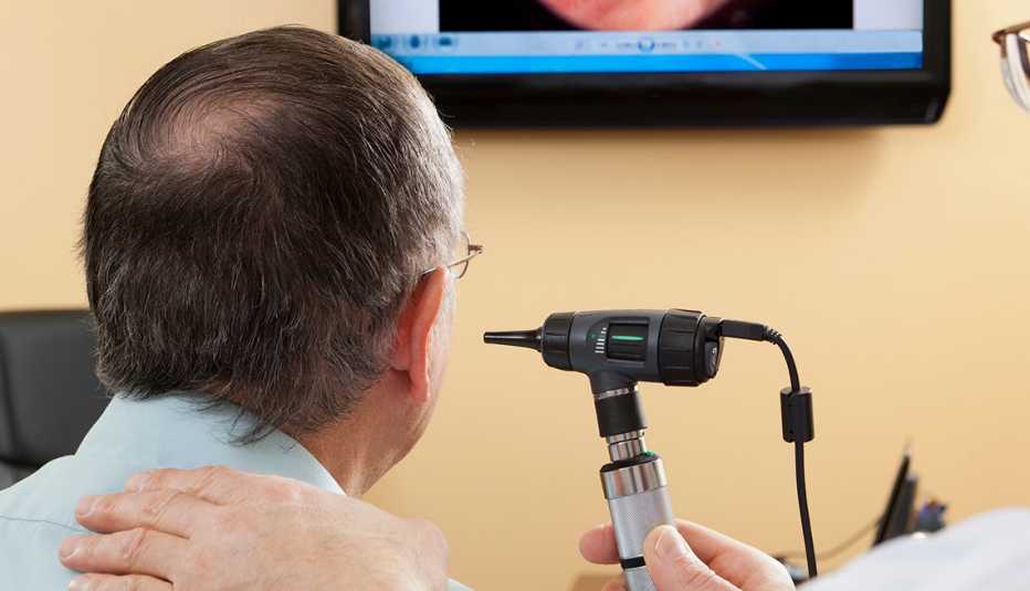 Doctor giving a man an ear exam Doctor giving a man an ear exam