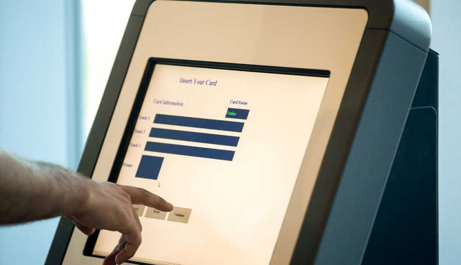 man using airline kiosk at airport