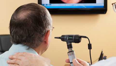 Doctor giving a man an ear exam