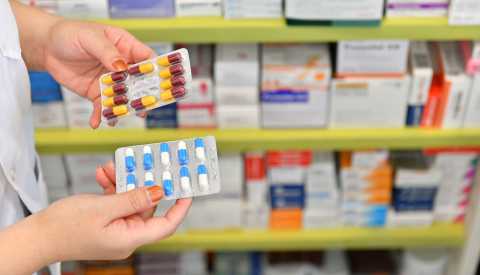 pharmacist holding medicine capsule pack at the pharmacy drugstore