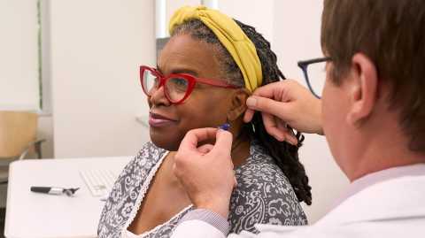 audiologist patient with doctor fitting a hearing aid